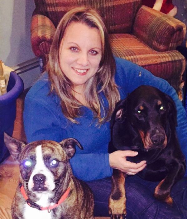 Beth posing with two dogs indoors